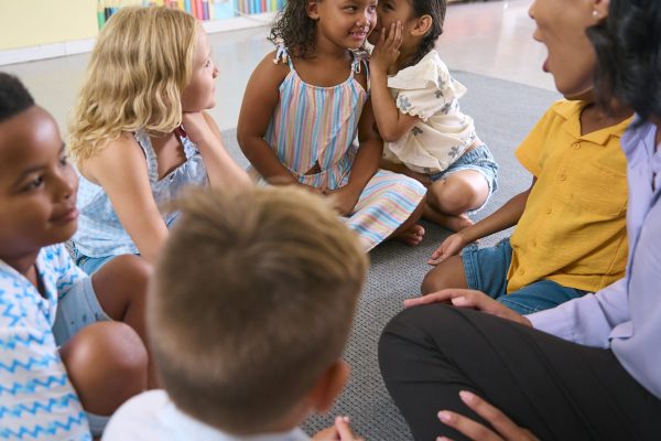 Multi-Cultural Primary Or Elementary School Class With Students Whispering To Each Other